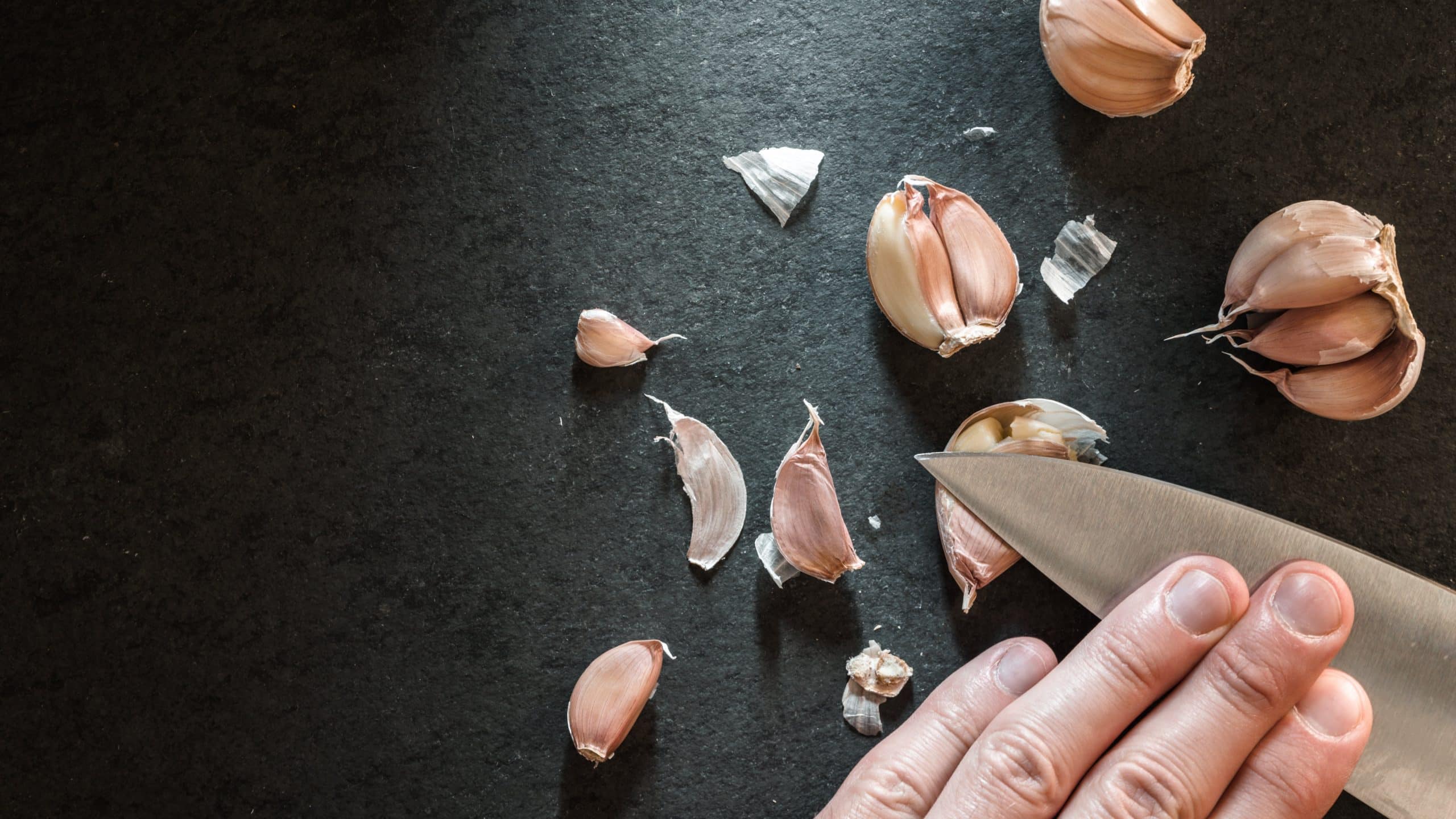 Peeling the garlic with a knife.